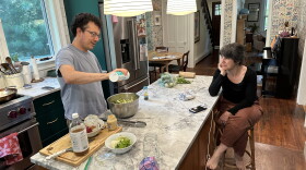 Author Andrew Leland prepares dinner in Northampton, Massachusetts, as his wife, Smith College professor Lily Gurton-Wachter, looks on, June 22, 2023.