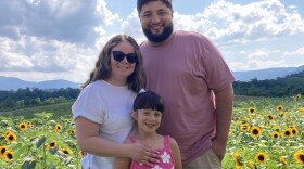 Ann Amairi joins her husband and daughter for a sunny family photo.