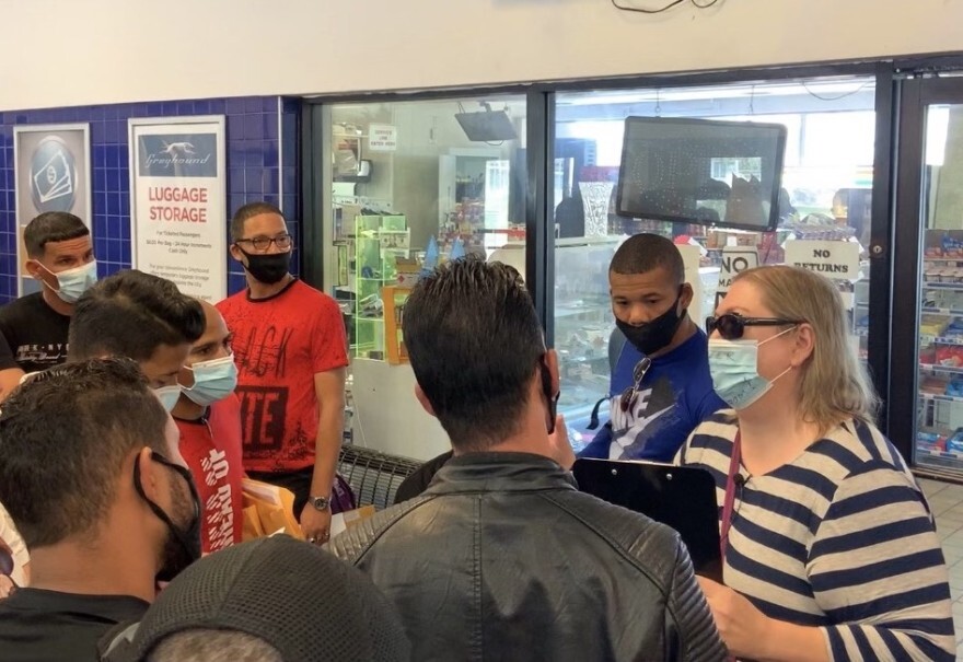 Natchez Network's Elisabeth Grant-Gibson speaks with detainees released from River Correctional Center inside the Baton Rouge Bus Station.