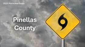 A yellow hurricane emergency sign in front of grey clouds