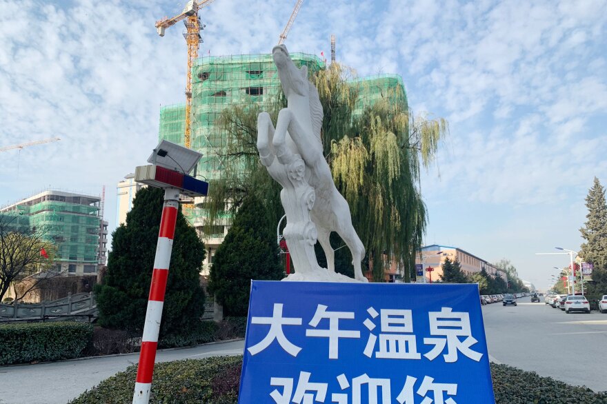 A sign for the Dawu Hot Springs village, under construction, in a thoroughfare in the company town.