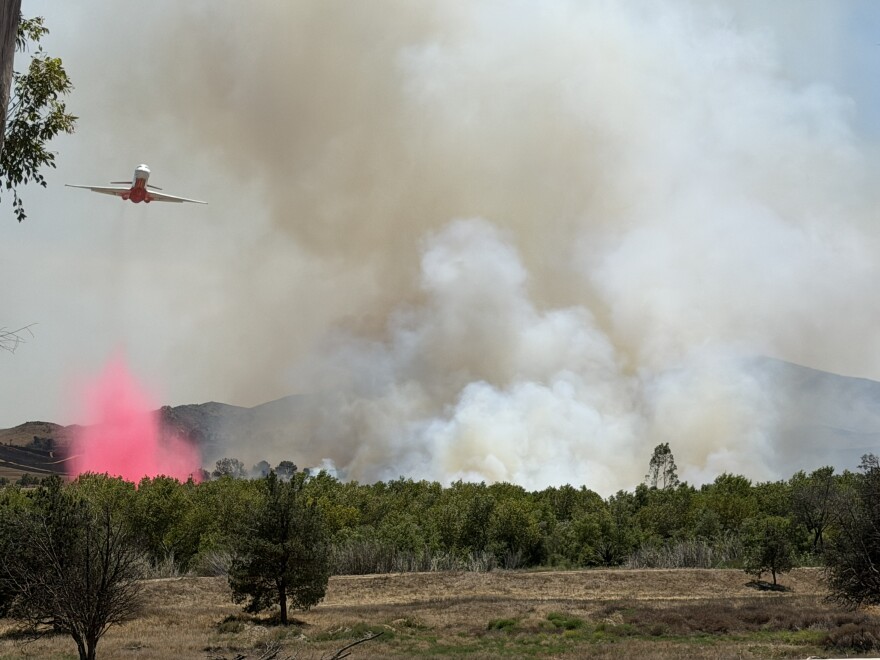 Firefighter aircraft drops retardant over the Bain Fire, which has burned more than 800 acres near Riverside and Jurupa Valley, on Tuesday, May 19, 2026.