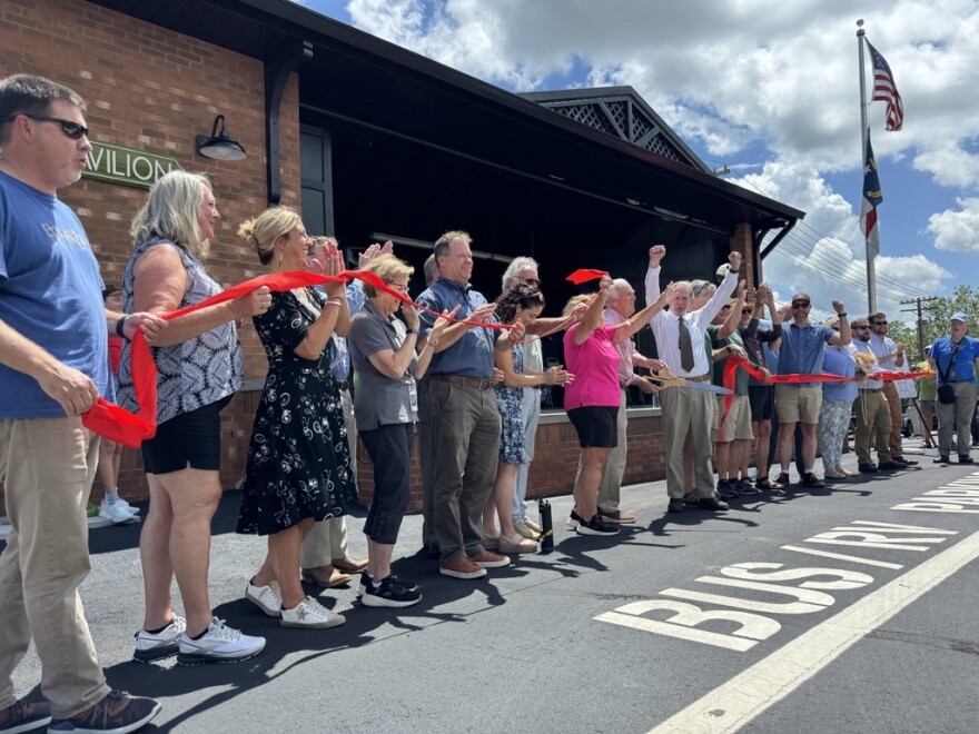 Officials from Henderson County and neighboring municipalities cut a ceremonial ribbon for the opening of the Ecusta Trail at the county's visitors center on July 18, 2025.