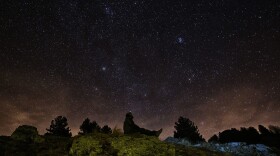 A photographer looks at the sky at night to see the annual Geminid meteor shower on the Elva Hill, in Maira Valley, near Cuneo, northern Italy on Dec. 12, 2015. (Marco Bertorello/AFP via Getty Images)