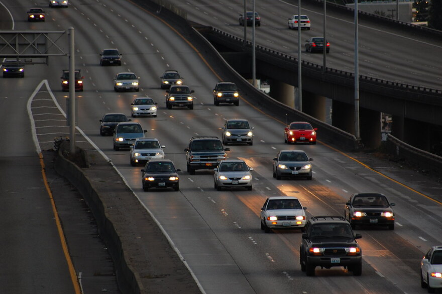 Vehicles travel on a roadway at night