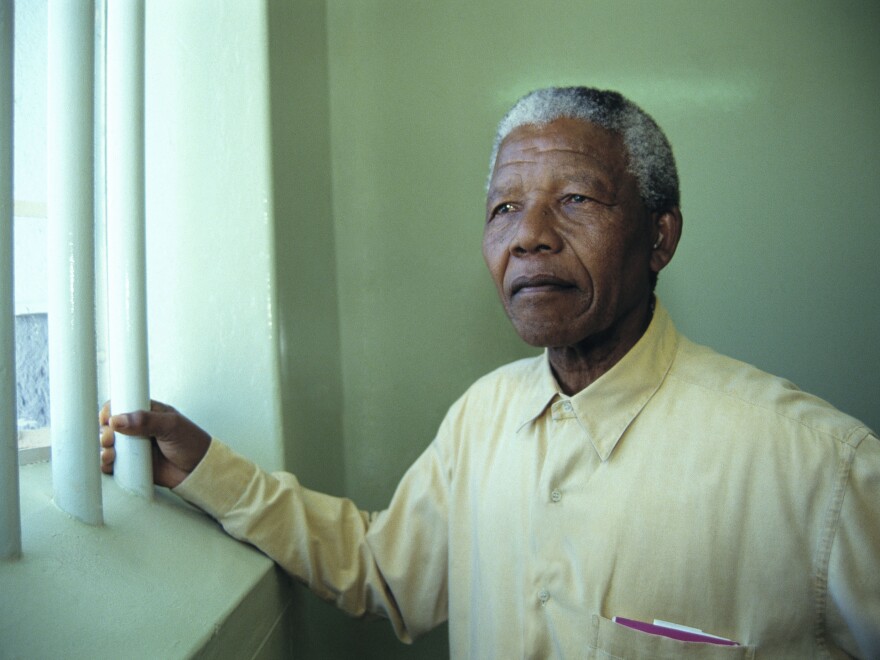 Mandela and other inmates faced harsh conditions during his many years at Robben Island prison. In the final year of his detention, the South African authorities put him in a private cottage where he had a swimming pool and a cook. Mandela is shown here during a return visit to his old Robben Island cell in 1994.