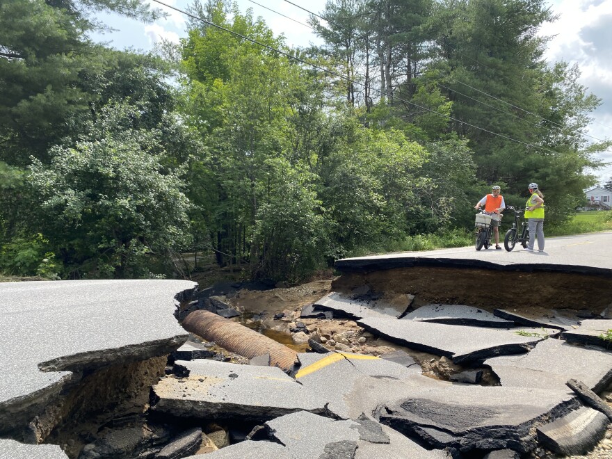 Richard and Corey Gillis biked out to a washed-out section of High Street in South Paris on Monday, July 17, 2023. The Maine Department of Transportation says a four-foot wide culvert failed during a heavy rainstorm one day earlier.