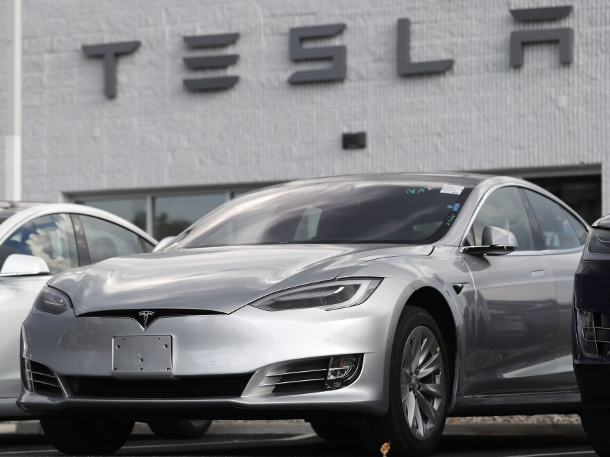 FILE - This July 8, 2018 photo shows Tesla 2018 Model 3 sedans sit on display outside a Tesla showroom in Littleton, Colo. Late last year, Tesla Inc. was fully charged and cruising down the highway on Autopilot. Shares were trading above $370 each, sales of the Model 3 small electric car were strong and the company had appointed a new board chair to rein in the antics of CEO Elon Musk. But around the middle of December 2018, investors started having doubts about the Wall Street darling’s prospects for continued growth. The stock started a gyrating fall that was among the worst in company history. (AP Photo/David Zalubowsi, File)