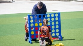Gov. JB Pritzker plays Connect 4 with children following an event to open a new sports park in Springfield on April 28, 2026.