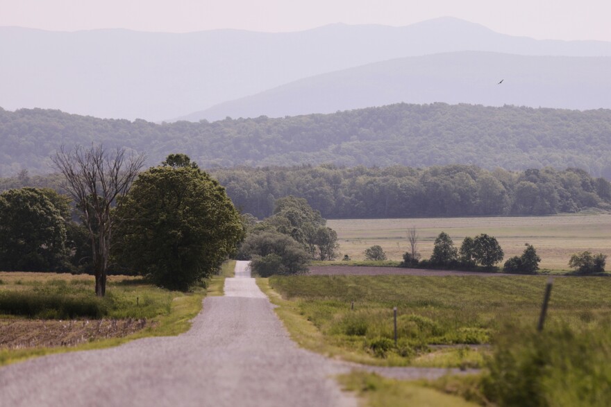A landscape view with hazy skies over mountains and fields