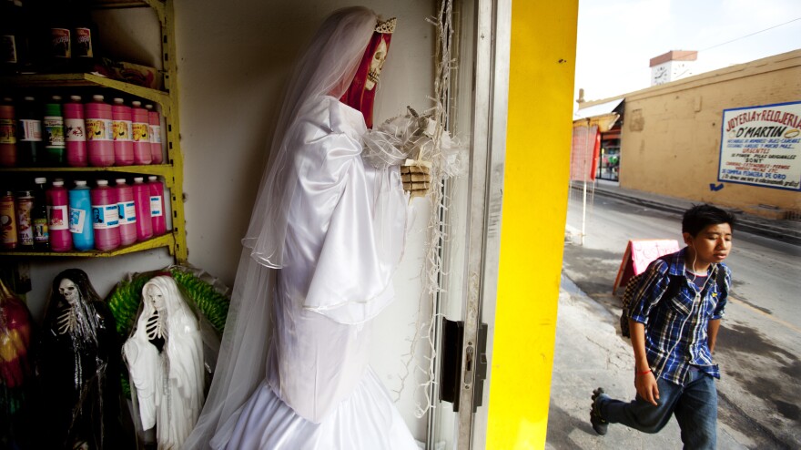 <em>La Patrona,</em> a <em>botanica</em> owned by Senora Tina in Matamoros, Mexico, sells statues, candles and mini figurines of <em>Santa Muerte.</em> Senora Tina says the cult of Saint Death is growing fast north of the border, where she has many clients who travel to Matamoros for consultations.