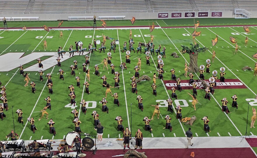 A variety of drum and bugle corps performing on a football field