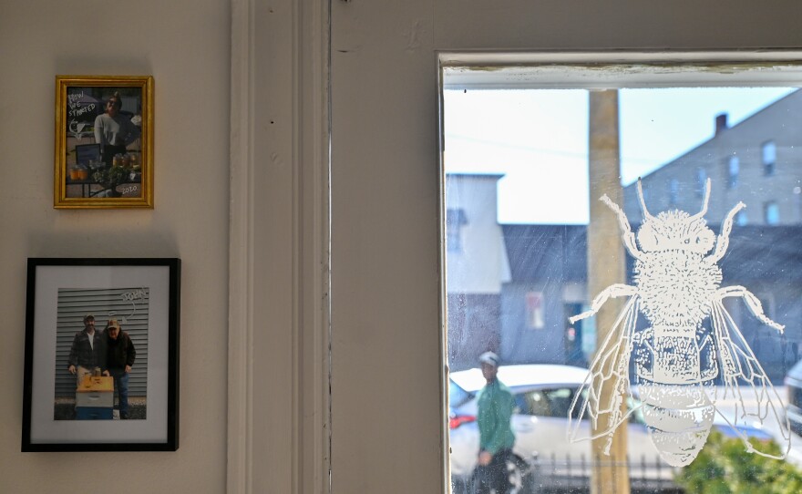 A portrait of Old Man John hangs at the entrance of the shop.