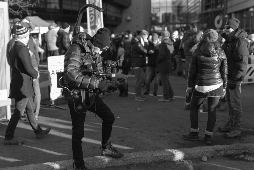 A videographer gathers footage in a crowd.