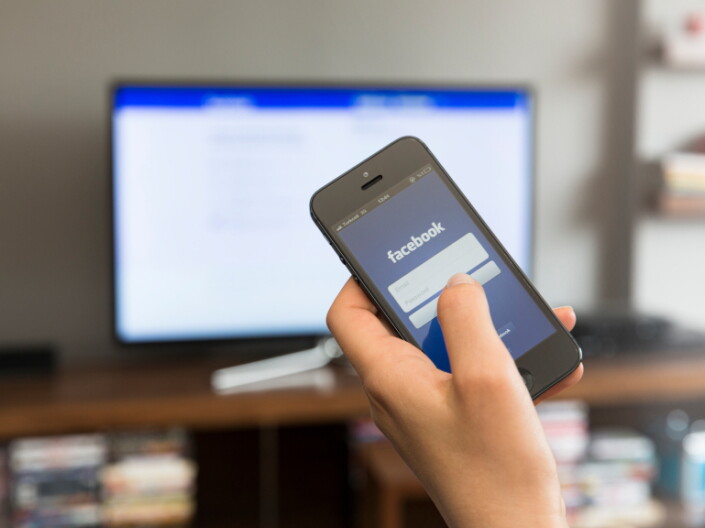 A person looks at Facebook on their phone.