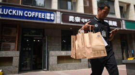 Luckin Coffee customers use an app and can pick up their coffee in three minutes or have it delivered. Above, a deliveryman in Beijing.