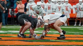 Syracuse FOGO John Mullen (27, White) meets at midfield for a faceoff against Harvard on February 22, 2025.