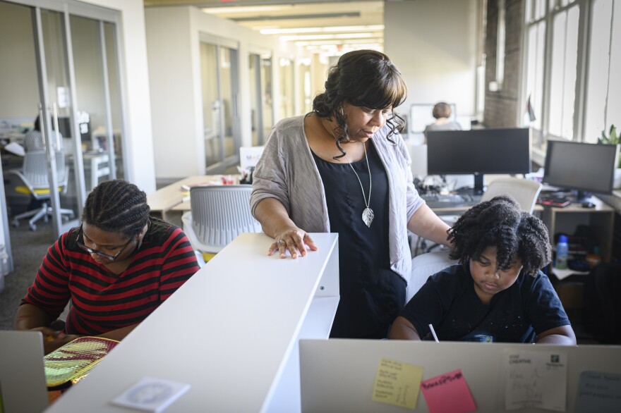 Ashana Bigard helps her children, Aiden Marie Bigard-Sallier (left), 13, and Brenton Bigard-Sallier, 8, with their homework after school at her office in New Orleans. Bigard is opposed to school closures, saying they are destabilizing and even traumatizing for students.