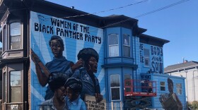 Side view of the mural of four black women on a victorian in West Oakland. The title reads "Women of The Black Panther Party."