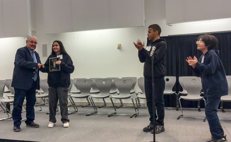 Finalists Jacius Skinner and Christian Hernandez (right) applaud Smriti Parajuli on her big win.