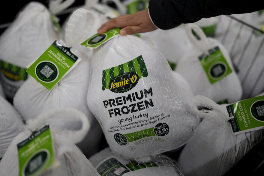 A shopper checks premium frozen young turkey at a grocery store in Glenview, Ill., Monday, Nov. 25, 2024.