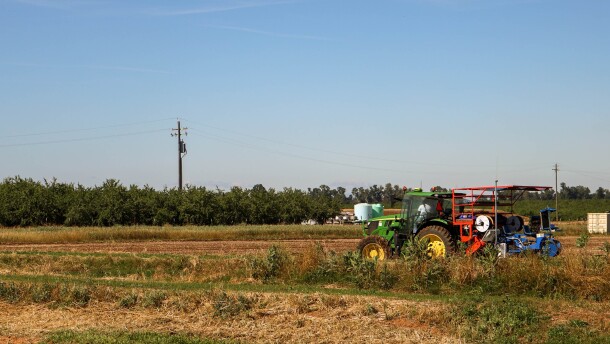Students work with employees on a tractor at UC Merced’s experimental “smart farm.”