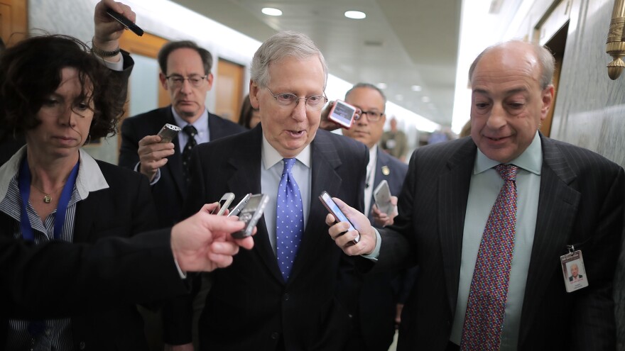 Senate Majority Leader Mitch McConnell talks with reporters after leaving a news conference on the tax overhaul in the Dirksen Senate Office Building on Capitol Hill.