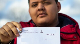 Luis Vazquez holds a letter from the Department of Workforce Development saying he owes back over $10,000 in unemployment benefits.