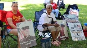 Debbie Fultz Martin (left) and Karen Swindler display photos of their husbands outside the U.S. Capitol on June 4, 2026. Both men died of cancer after serving at Camp Lejeune.