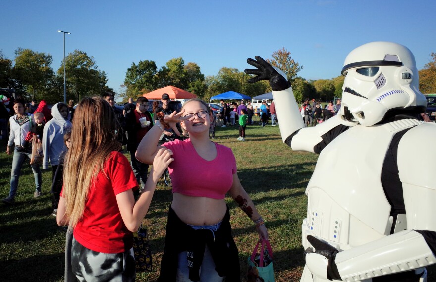 A Stormtrooper from the Gem City Squad does an exploding fist bump with some fans at a Trunk or Treat party in Huber Heights.