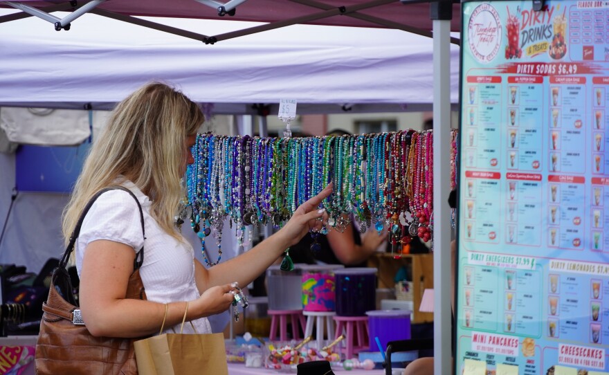 A shopper examines jewelry at a booth during Girls Night Out in Ocala, Fla., on June 6, 2026.