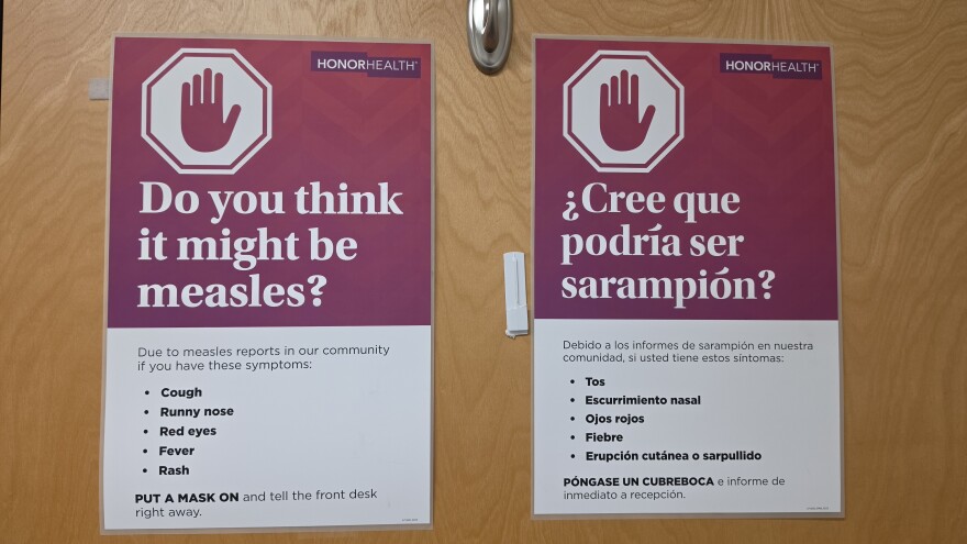  A sign asking about measles symptoms on a hospital door.
