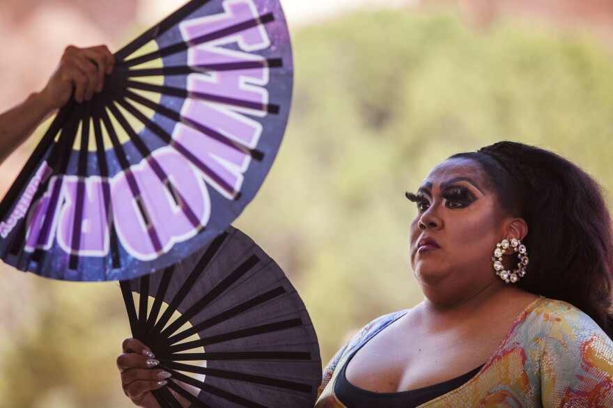 Chanel Ticey uses fans to try and beat the heat at Diné Pride. Ticey is originally from the eastern agency of the Navajo Nation but relocated to Albuquerque, N.M., where she found her "chosen family" through drag.