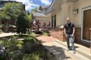 A man stands in front of a house. 