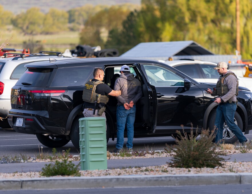 Agents take a man into custody near the Smith's gas station in Heber City, April 21, 2026.