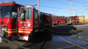 East St. Louis fire trucks sit parked with hoses running out of them.