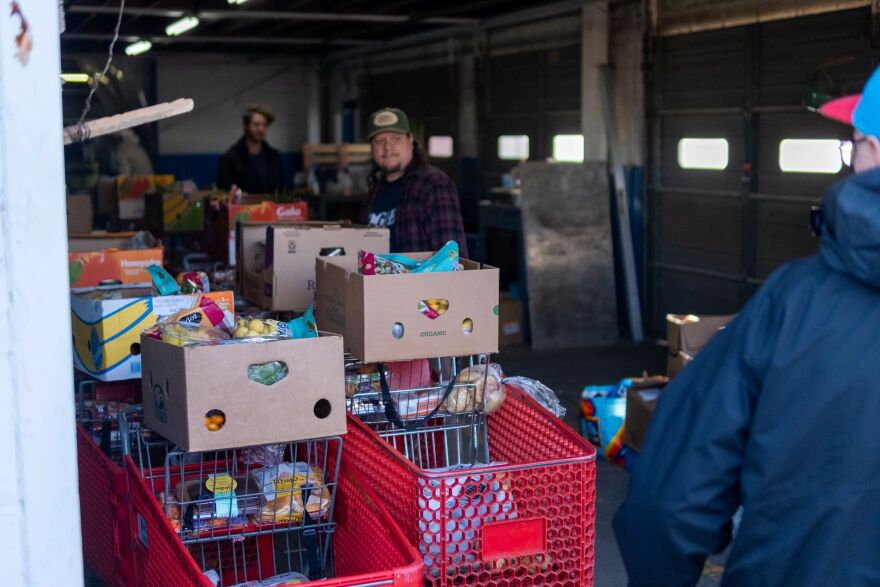 Volunteers and workers line up shopping carts of groceries for the Urban Mission's drive-thru food distribution in northwest Oklahoma City.