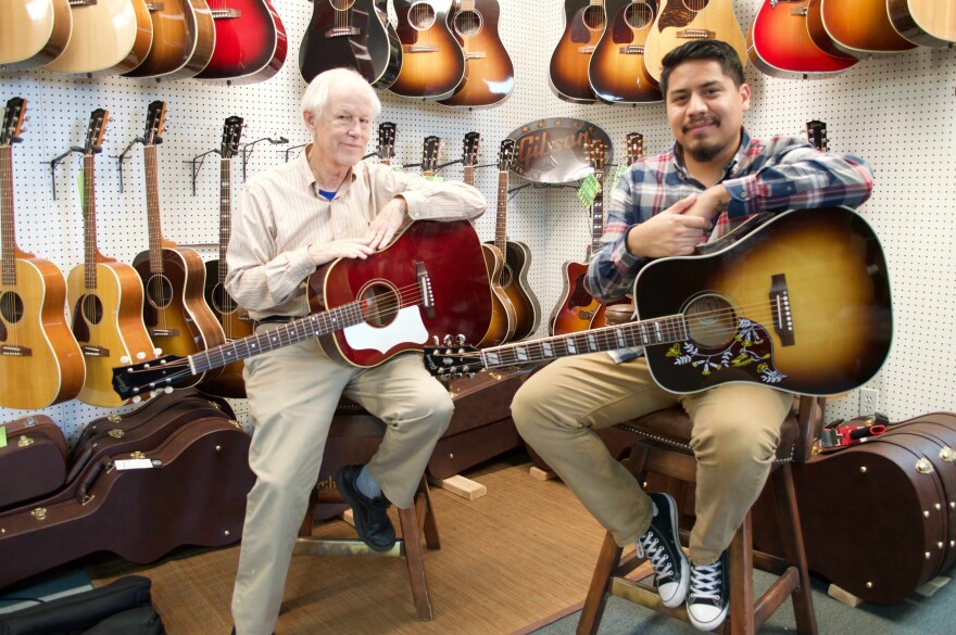 Southpaw Guitars owner Jim Duncan (L) with the store's manager, his son Omar.