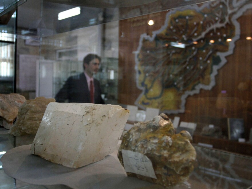 A journalist walks by an exhibit of minerals on the way to a news conference by the Afghan minister of mines, in Kabul in 2010.
