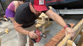 Adrian Girth works on a bench to post near a Wave bus stop. The benches will get a paint job before being placed. He says the DSA maintains and monitors the benches they've put out, though they don't have permits to place them.