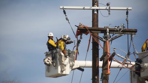 PNM officials announced Feb. 25, 2026, that the utility is implementing a new way to alert residents in wildfire-prone areas before the utility shuts off their power during severe weather. Above: Workers repair power lines in Albuquerque on Feb. 25, 2026.