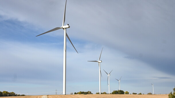 White wind turbines rise up from harvested fields and stand against a blue sky. Wind turbines near Burlington Junction in northwest Missouri, Oct. 15, 2022.