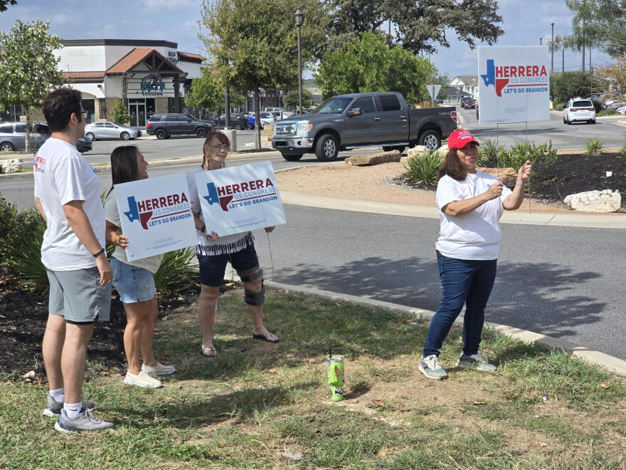 Volunterrs for the Brandon Herrera congressional campaign give away political signs.