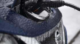 Icicles hang from an electric vehicle that is parked at a charging station. (Jenny Kane/AP)