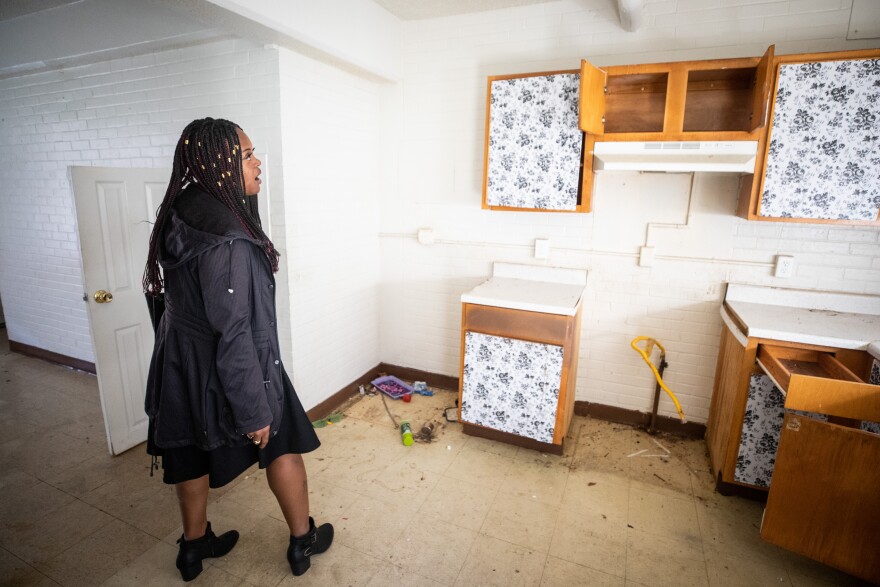 A person stands in an empty kitchen