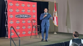 Man speaking into a microphone on a stage