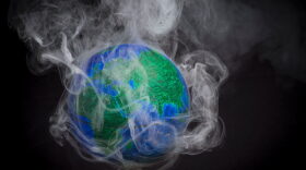 A picture taken on November 10, 2015 shows a small globe surrounded by smoke to illustrate global warming. (Lionel Bonaventure/AFP/Getty Images)