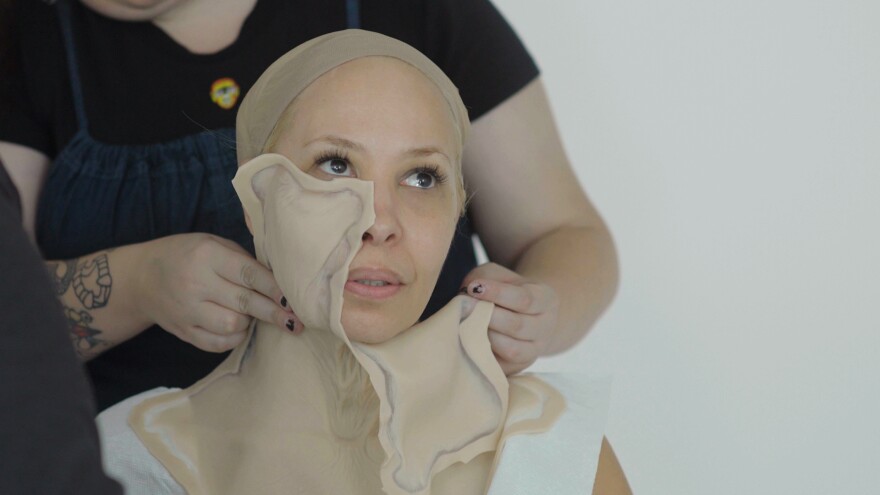 Carol Causieestko having fake skin applied to face and neck