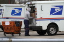 A USPS employee loads a truck outside post office in Wheeling, Ill., Friday, Dec. 3, 2021.