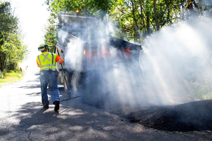 A dump truck deposits the steaming asphalt on a patching project in Harrisonburg.